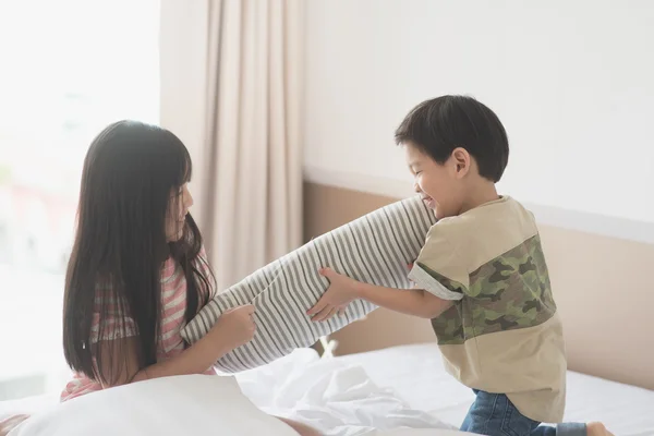 Азиатский ребенок дерётся на подушках в гостиничном номере — стоковое фото