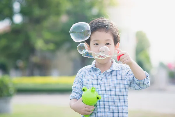Söta asiatiska barn blåser en såpbubbla — Stockfoto