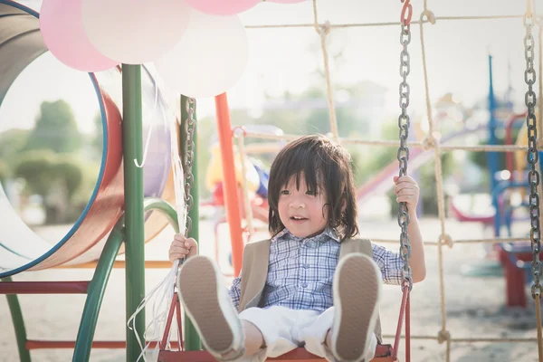 Asiatiska barn på en gunga sommardag — Stockfoto