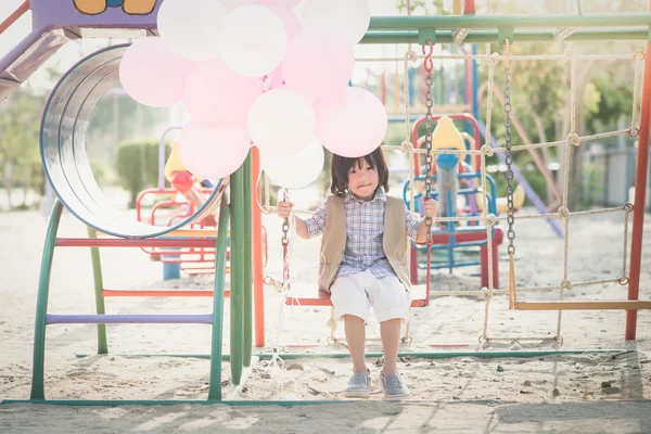 Asiática niño en un columpio en verano día — Foto de Stock