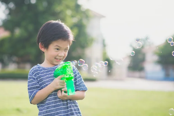 Ασιατικές παιδί γυρίσματα φυσαλίδες από Bubble Gun — Φωτογραφία Αρχείου