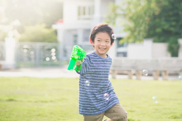 Ασιατικές παιδί γυρίσματα φυσαλίδες από Bubble Gun — Φωτογραφία Αρχείου