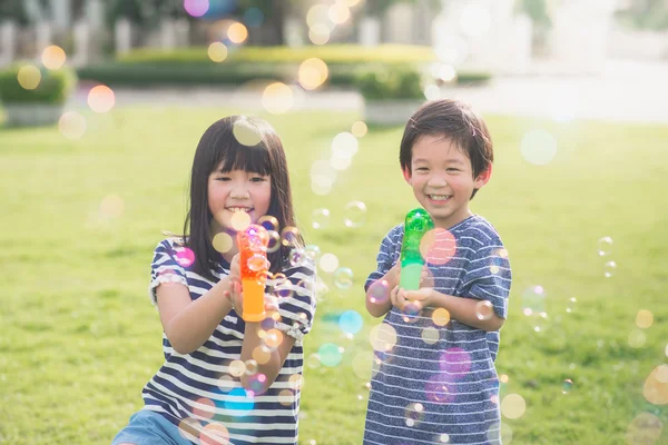 Asiatiska chid skjuta bubblor från Bubble Gun — Stockfoto