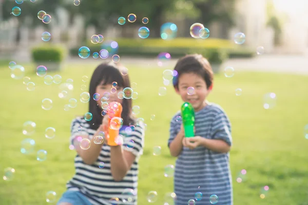 Asiatiska chid skjuta bubblor från Bubble Gun — Stockfoto