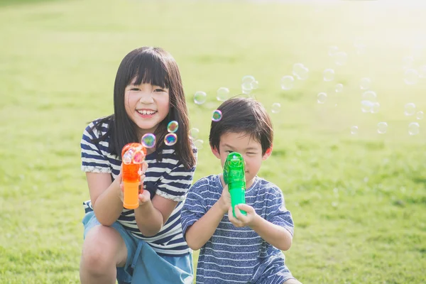 Asian chid Shooting Bubbles from Bubble Gun — Stock Photo, Image