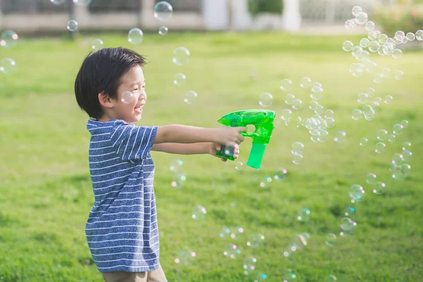 Ásia criança tiro bolhas a partir de bolha arma — Fotografia de Stock