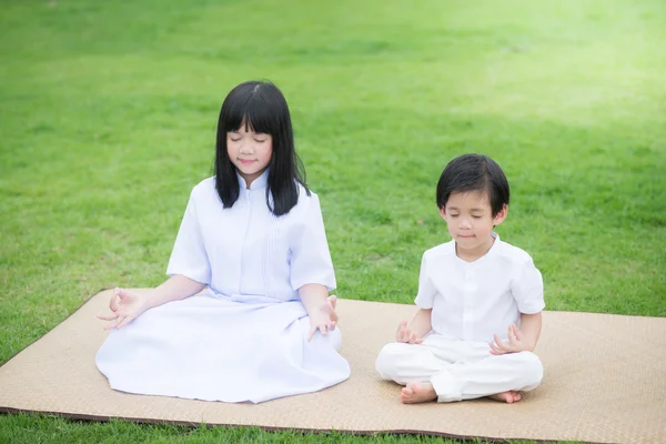 Asijské dítě krmení jelenů na sobě bílé šaty meditovat — Stock fotografie