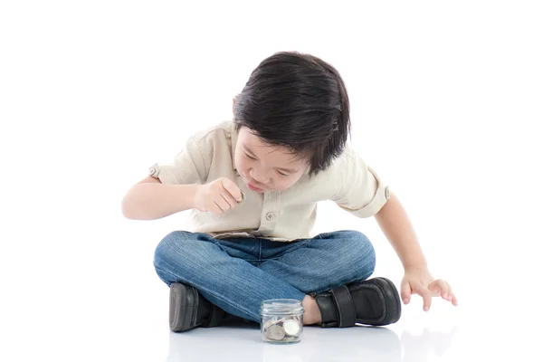 Lindo niño asiático ahorro de dinero en botella de vidrio — Foto de Stock