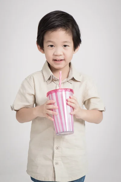 Милый азиатский ребенок пьет с бумажной соломинкой — стоковое фото