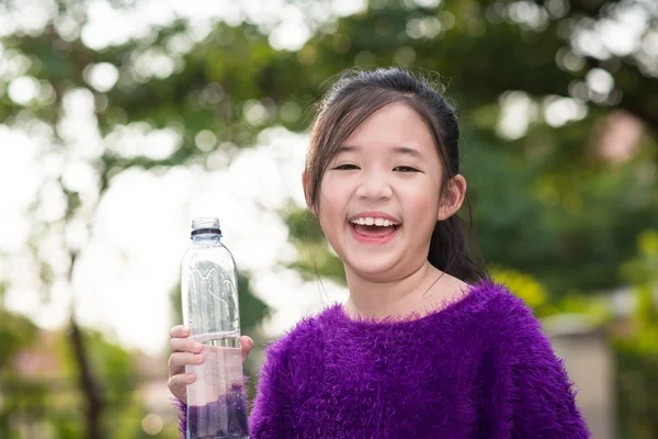 Beautiful asian girl drinks water from a bottle — Stock Photo, Image