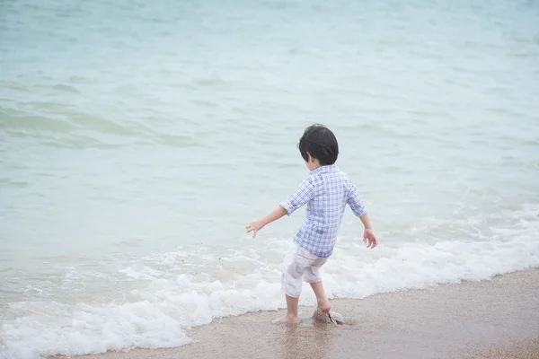 Aziatisch jongen spelen op het strand — Stockfoto