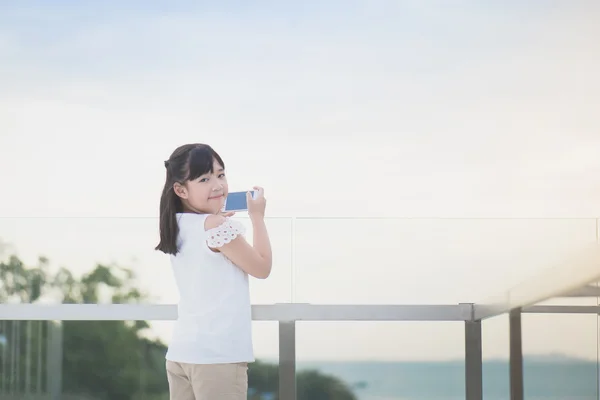 Menina asiática usar telefone inteligente tirar foto — Fotografia de Stock