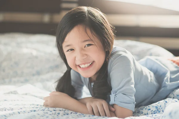 Menina asiática deitada na cama — Fotografia de Stock