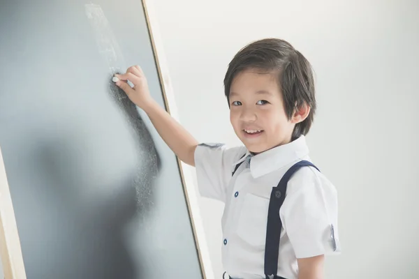 Kind schrijven op het schoolbord — Stockfoto