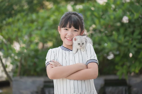 Vacker asiatisk tjej innehav härliga kattunge med solsken i parken — Stockfoto