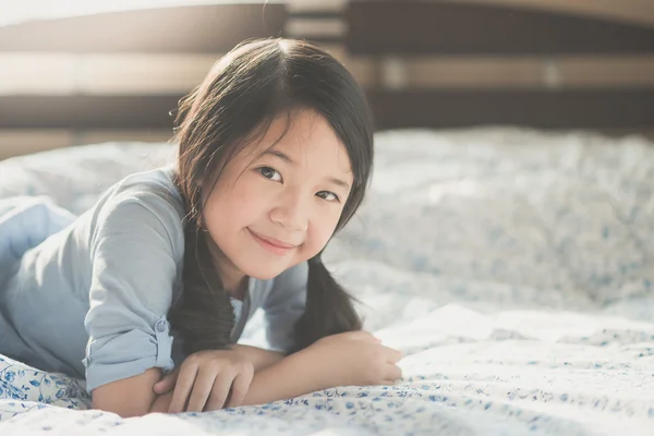 Ragazza asiatica sdraiata sul letto — Foto Stock