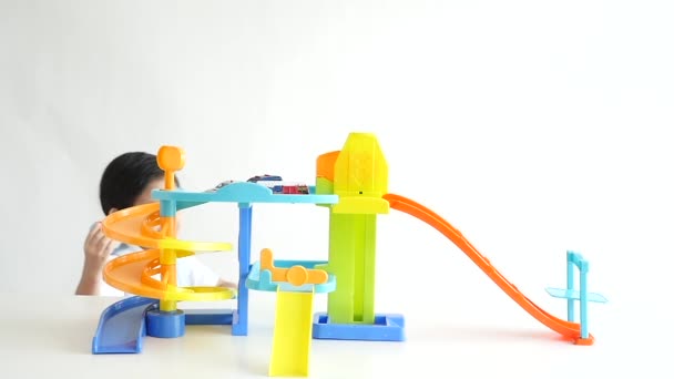 Cute Asian child playing toy cars on white background,slow motion — Stock Video