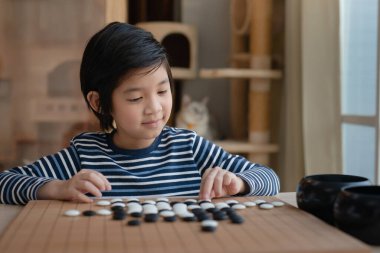 Yakışıklı Asyalı çocuk tek başına Çince go oyunu oynamayı öğrendi.