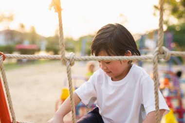 Yazın oyun parkında oynayan Asyalı çocuk