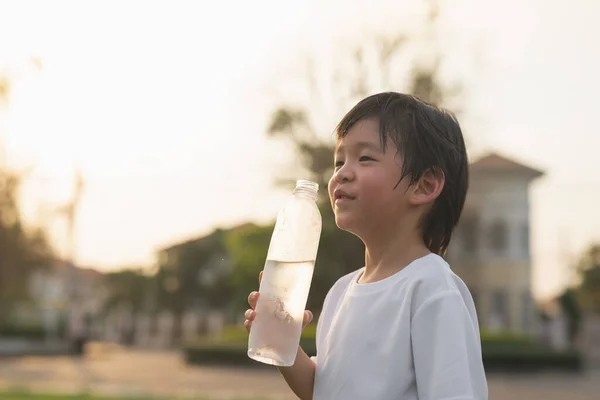 Söt Asiatisk Pojke Dricker Vatten Från Flaska Utomhus — Stockfoto