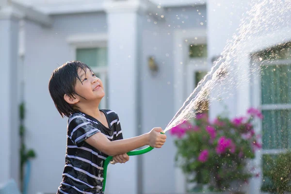 可爱的亚洲男孩在户外用软管玩水很开心 — 图库照片