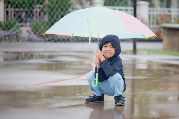 Szczęśliwy Azji Chłopiec Gospodarstwa Kolorowe Parasol Zabawy Parku Deszczu — Zdjęcie stockowe