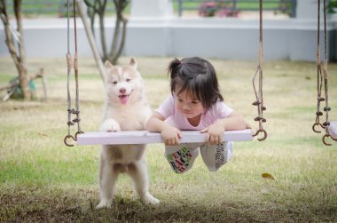 Asya bebek bebek salıncak ile köpek yavrusu üzerinde