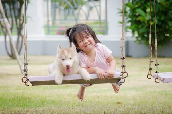 Asiático bebê no balanço com filhote de cachorro — Fotografia de Stock