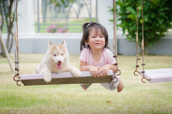 Asiatique bébé bébé sur swing avec chiot — Photo