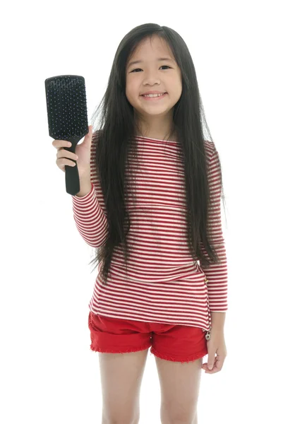 Pouco menina asiática sorrindo e escovando o cabelo — Fotografia de Stock