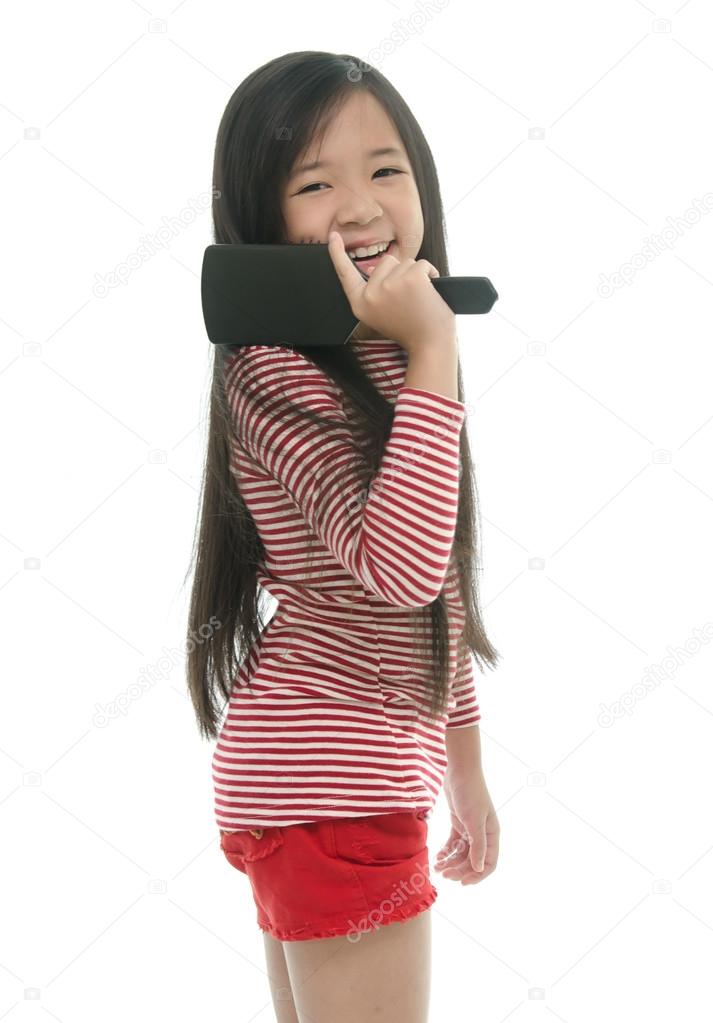 Little Asian Girl Smiling And Brushing Hair Stock Photo