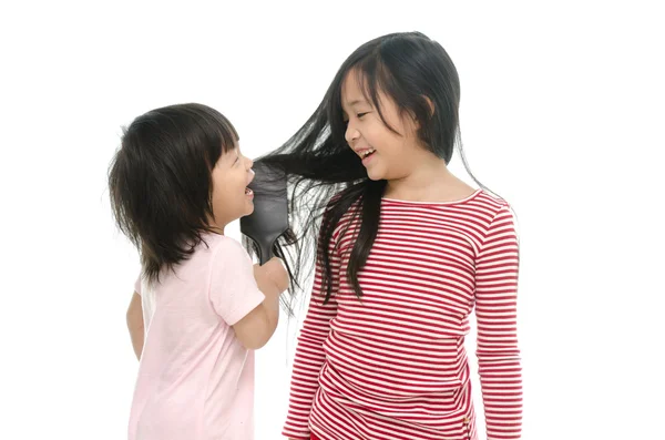 Poco asiático chico sonriendo y cepillado hermana cabello —  Fotos de Stock
