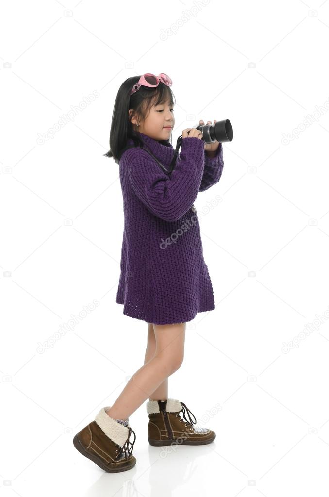 Little asian girl holding mirrorless camera 