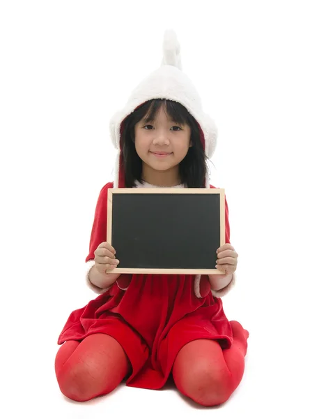 Asian girl in santa costume sitting and holding chalkboard — Stock Photo, Image