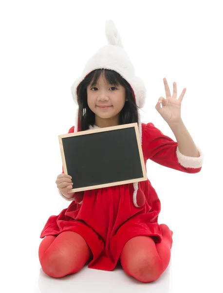 Asiatico ragazza in Santa costume seduta e tenendo lavagna — Foto Stock