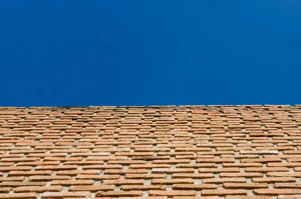 Bakstenen muur en blauwe hemel — Stockfoto