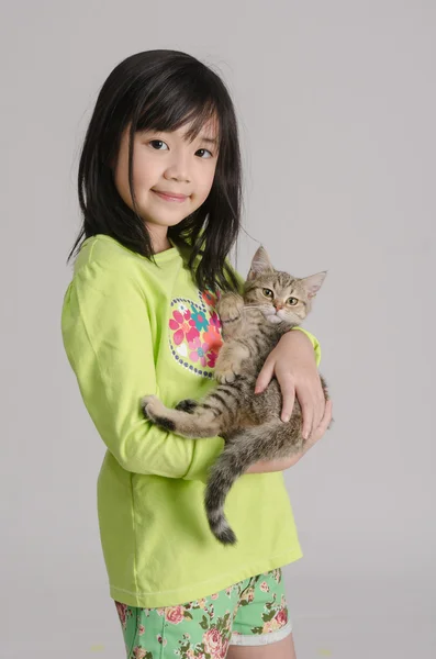 Bonito ásia menina abraçando um pouco gato — Fotografia de Stock