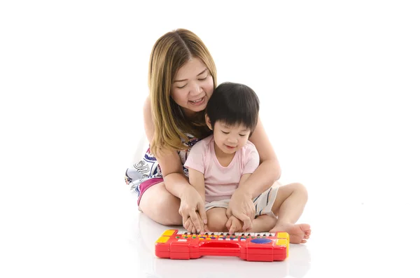 Mère mignonne enseigner à son fils enfant à jouer du piano jouet électrique — Photo