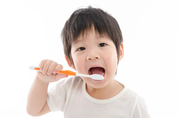 Carino asiatico baia spazzolatura denti su bianco fondo — Foto Stock