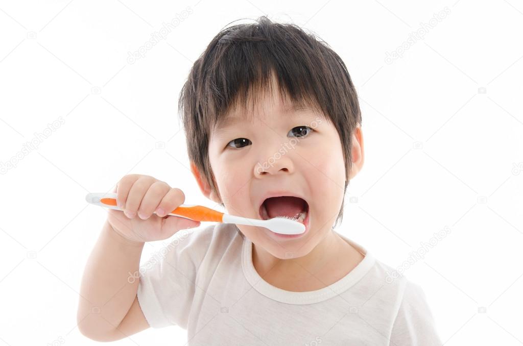 Cute asian bay brushing teeth on white background 