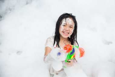 Asian girl smiling in foam party clipart