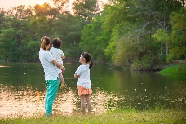 Asiática madre sosteniendo hijo y hablando con hija — Foto de Stock