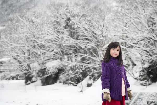 Bonito ásia menina sorrindo ao ar livre no neve — Fotografia de Stock