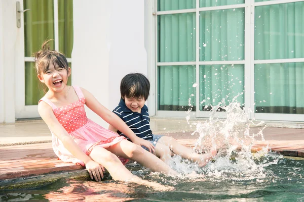 アジアの子供たちがプールで水しぶき — ストック写真