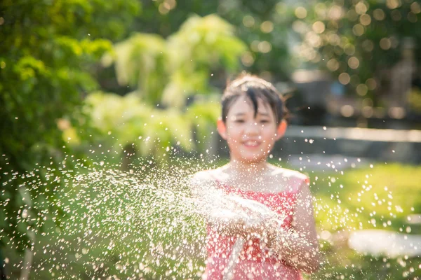 Oskärpa av asiatiska barn leker med vattenslang — Stockfoto