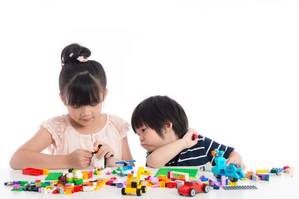 Pequeños niños asiáticos jugando con bloques de construcción coloridos —  Fotos de Stock