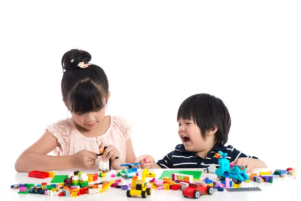 Pequeños niños asiáticos jugando con bloques de construcción coloridos —  Fotos de Stock