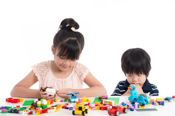Маленькие азиатские дети играют с красочными строительными блоками — стоковое фото
