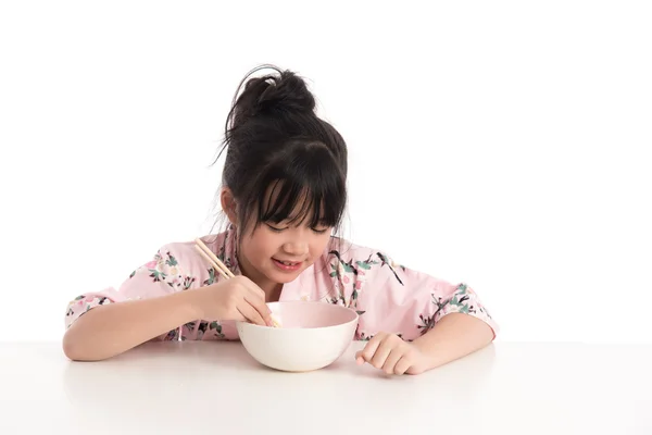 Pequeña chica asiática usando kimono y comiendo fideos — Foto de Stock