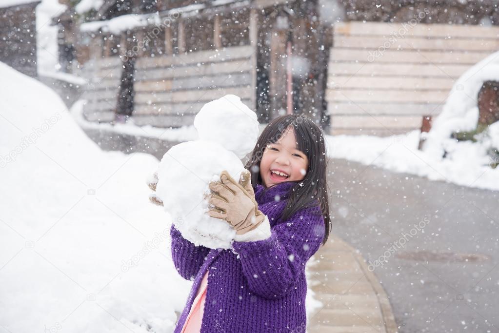 Cute asian girl smiling outdoors in snow 